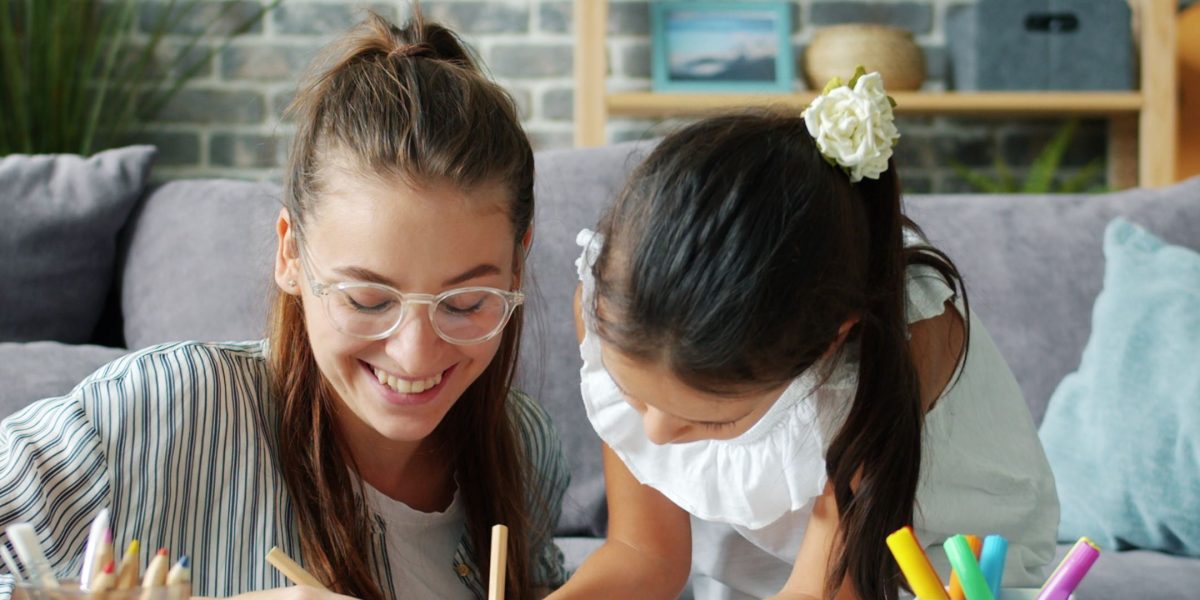 A parent and child engaged in a shared learning activity, representing the homeschooling experience.